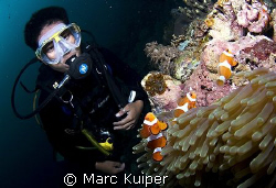 diveguide as model in front of anemone with western clown... by Marc Kuiper 
